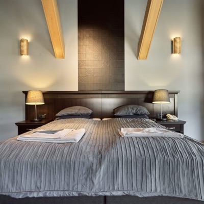 Bedroom with a double bed, dark wood headboard and exposed beams